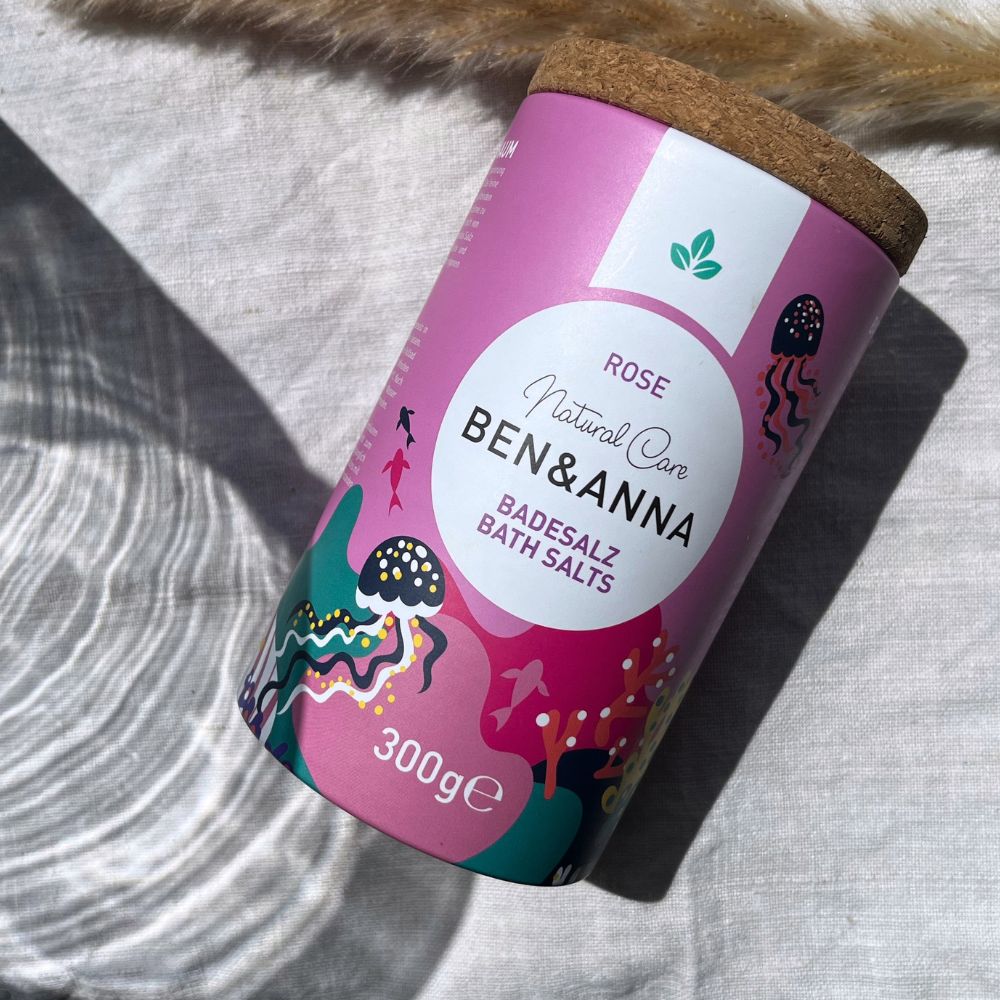 Badesalz mit Rosenduft von BEN&ANNA, zeigt eine offene Packung mit rosa Blüten und Salz für ein entspannendes Bad.
