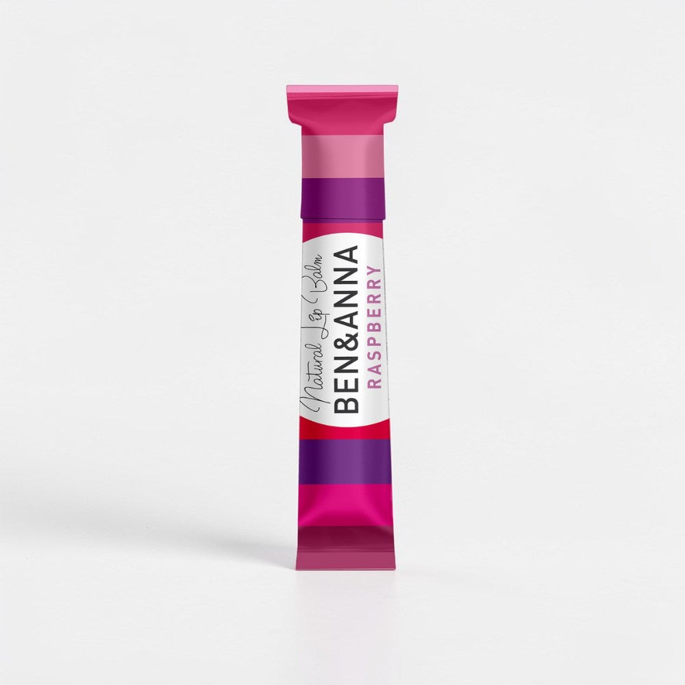Natürlicher Lippenbalsam von BEN&ANNA mit Himbeerduft, zeigt den Lippenbalsam in einer transparenten Verpackung mit Himbeeren.