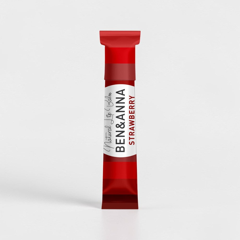 Natürlicher Lippenbalsam von BEN&ANNA mit Erdbeerduft, zeigt den Lippenpflegestift in einer offenen Verpackung.
